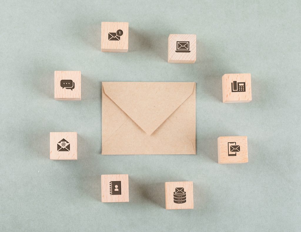 Conceptual of management with wooden cubes, envelope on sage color background flat lay. horizontal image